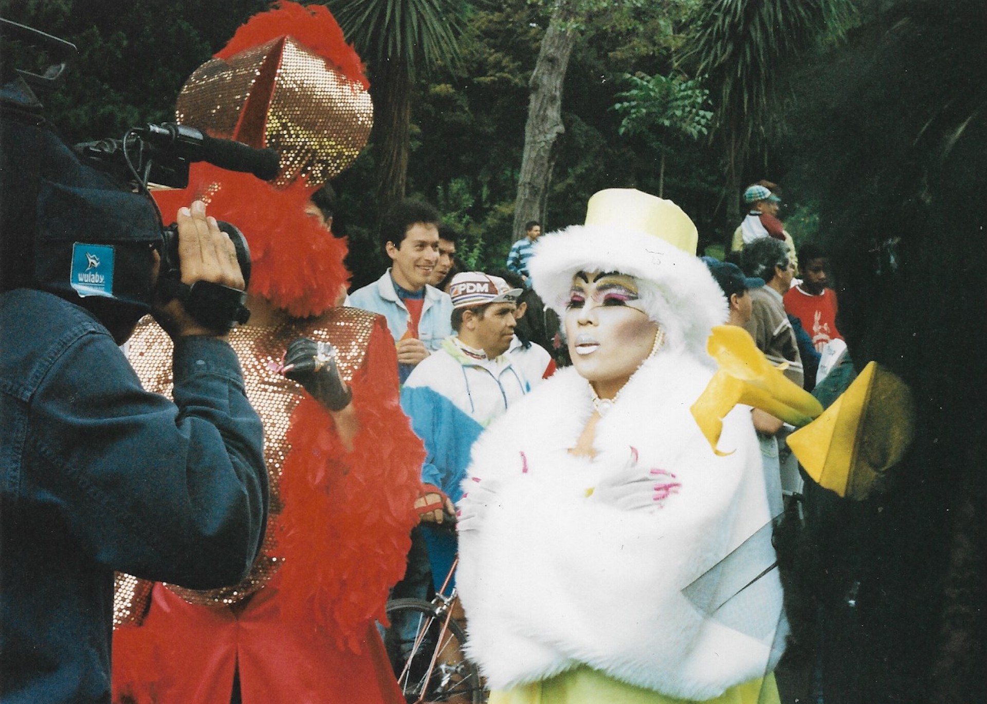 Drag de blanco, amarillo y rosa siendo grabada en video
