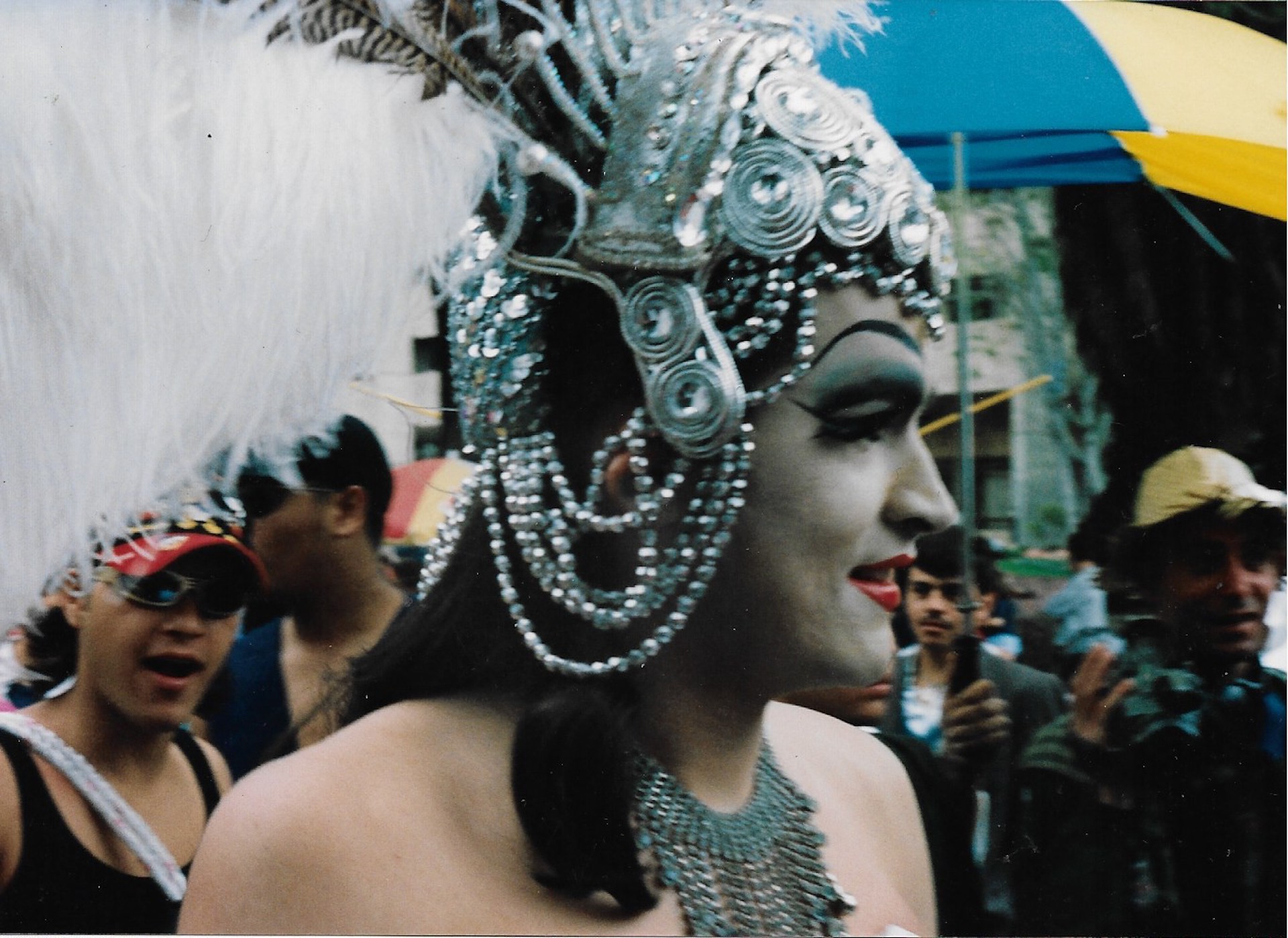 Retrato Drag: perfil de corona plateada y plumas blancas