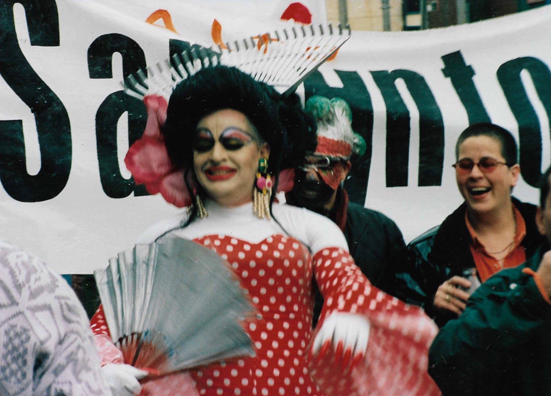 Drag de vestido rojo con puntos blancos marchando